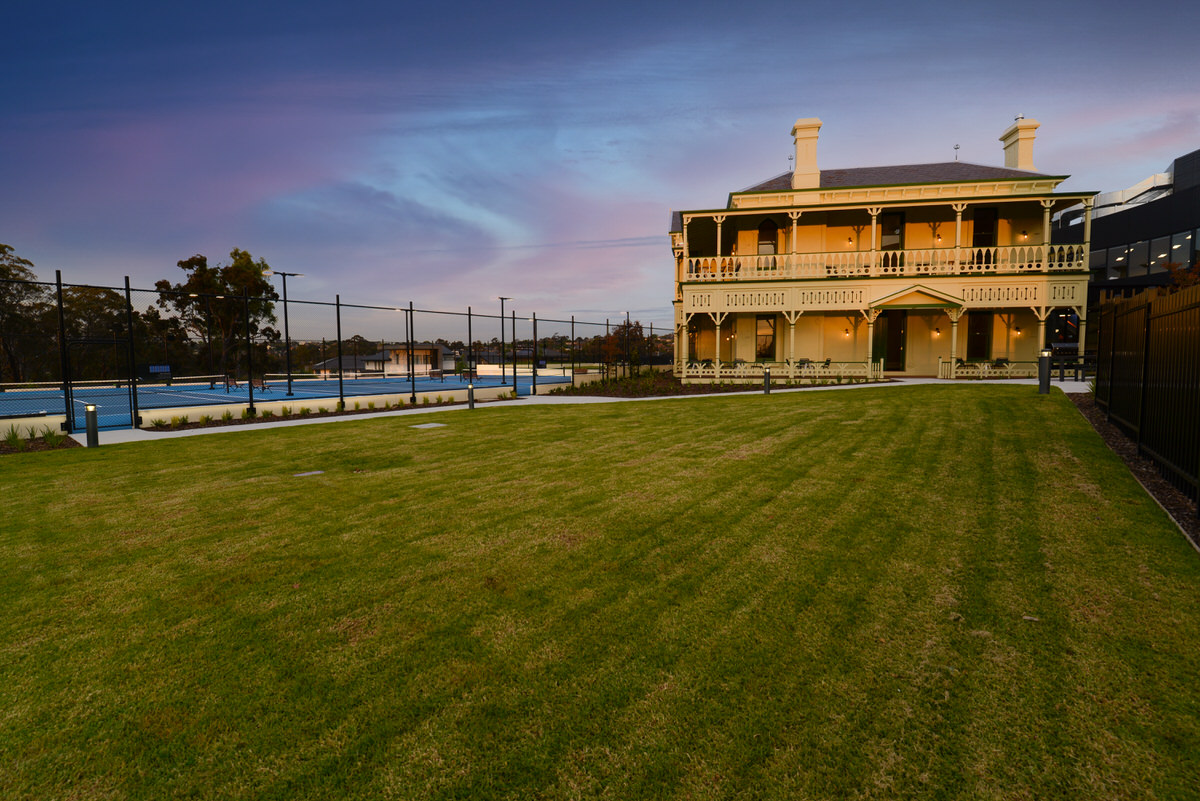 image overlooking Fitness Centre grounds with tennis court at dusk