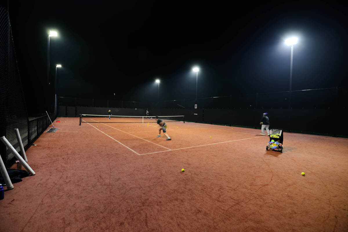 Tennis court with coaching under lights