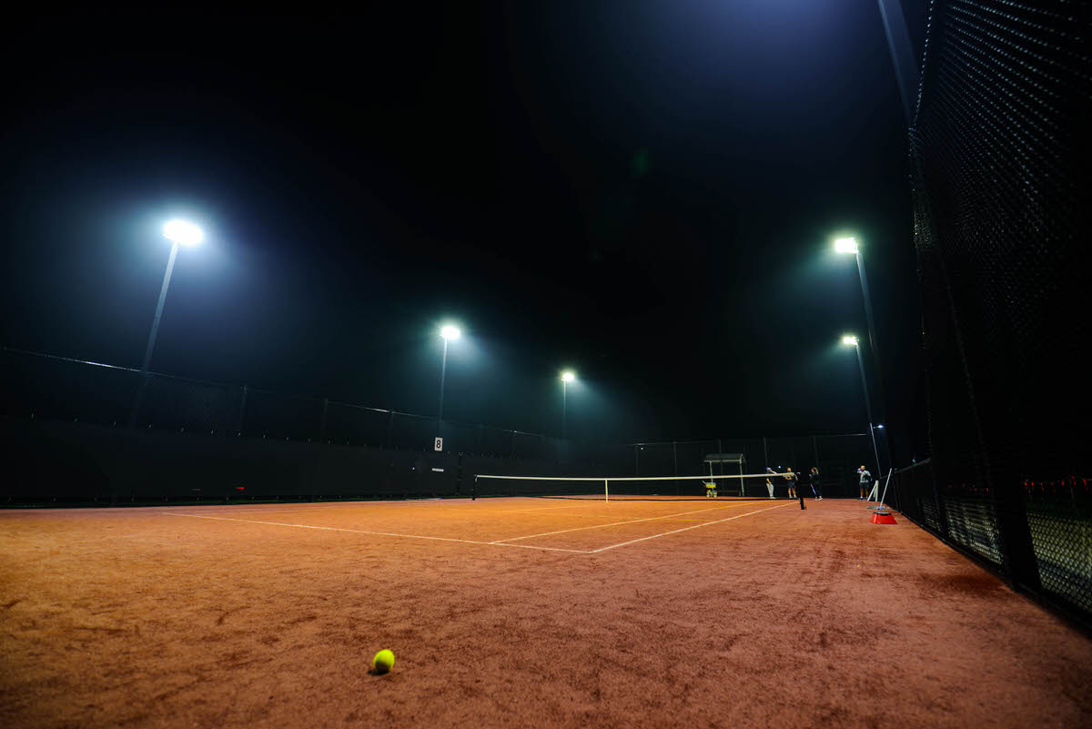 Wide angle shot of tennis court under lights